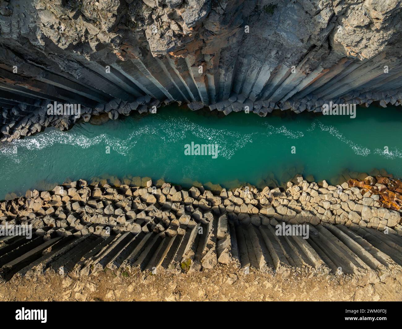 Canyon di magnifiche colonne di basalto, alta scogliera con luminoso fiume turchese, nel nord-est dell'Islanda, tiro aereo. Studlagil, concetto di bellezza naturale. Foto Stock