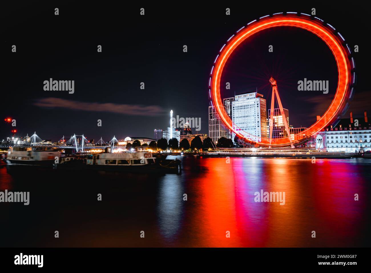 Una grande ruota panoramica illuminata sullo sfondo di luci colorate, Londra, Regno Unito Foto Stock