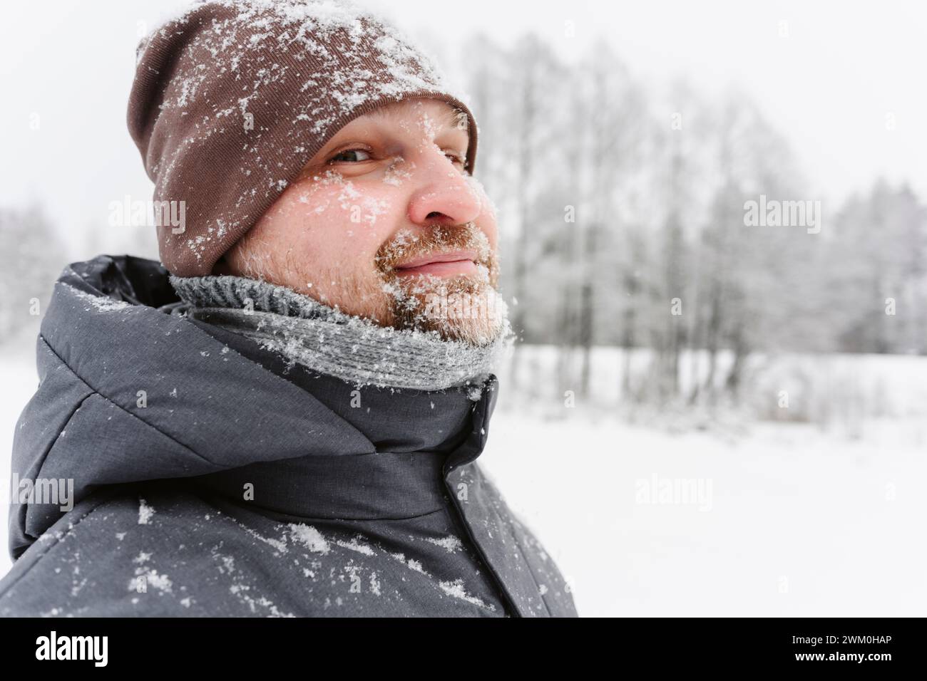Uomo maturo che indossa un cappello a maglia sul campo di neve Foto Stock