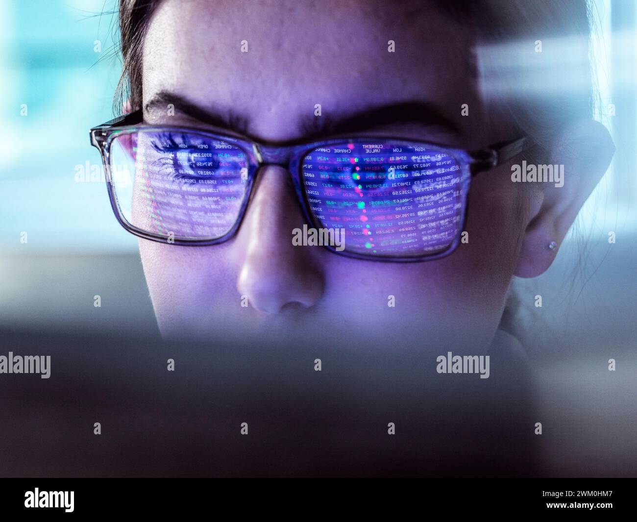 Donna d'affari che esamina i dati di borsa su computer Foto Stock