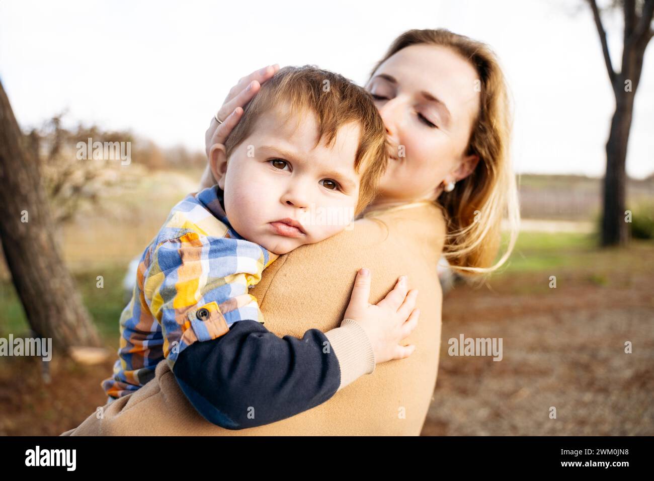 Donna che abbraccia il figlio tra le braccia Foto Stock