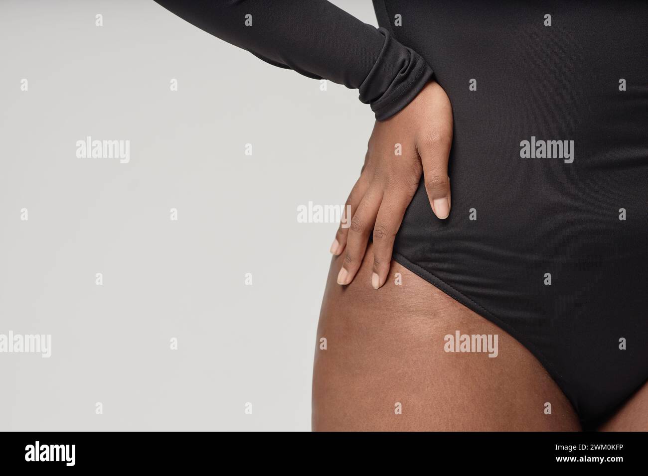 Donna che indossa un body nero su sfondo bianco Foto Stock
