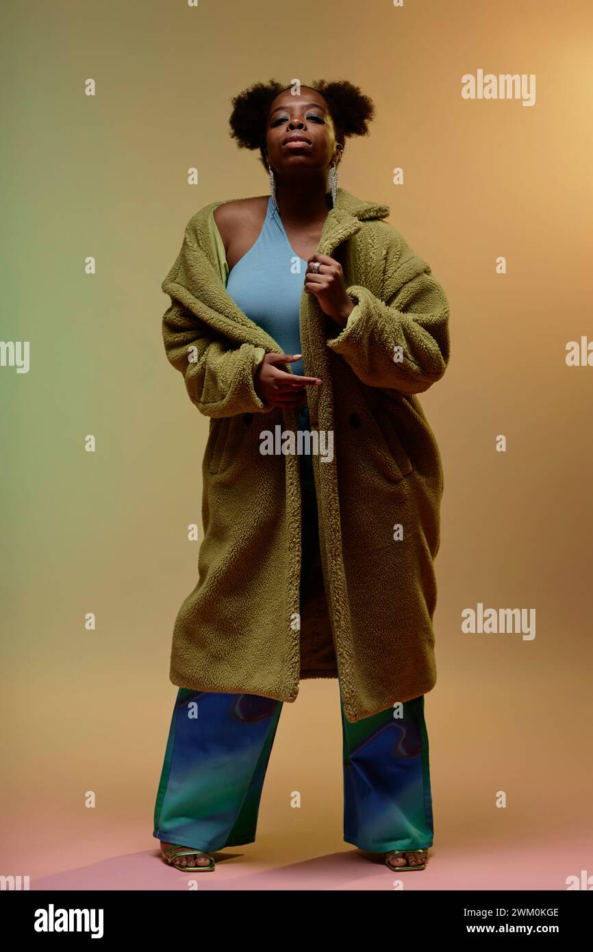 Donna che indossa un cappotto in pelliccia sintetica su sfondo sfumato Foto Stock