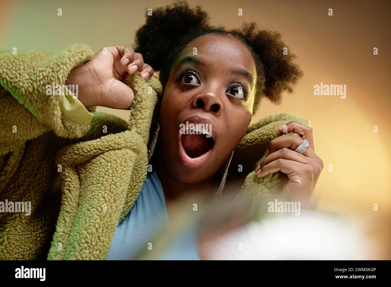 Donna sorpresa che indossa un cappotto in pelliccia sintetica Foto Stock
