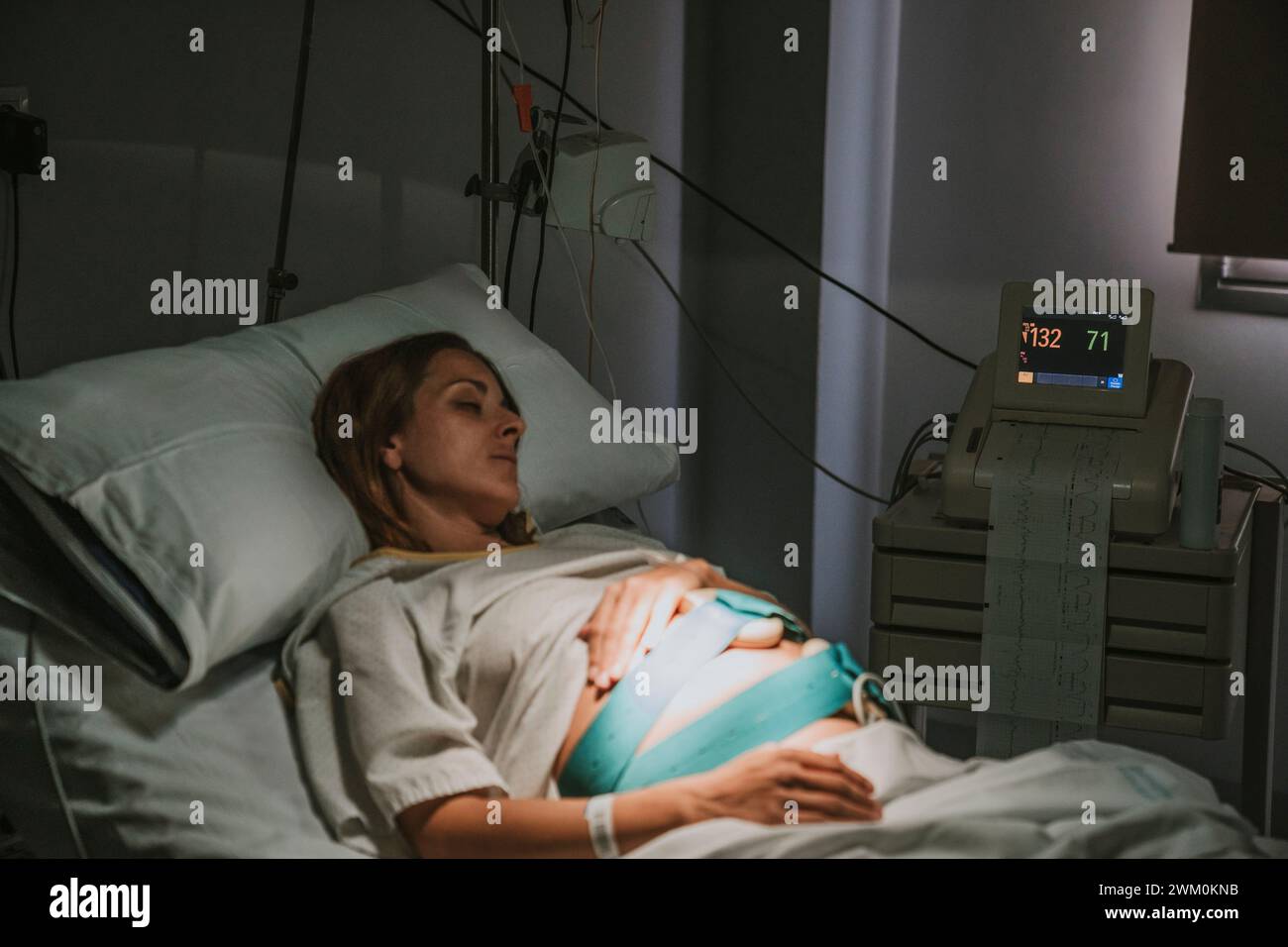 Donna incinta che riposa sul letto d'ospedale in sala parto Foto Stock