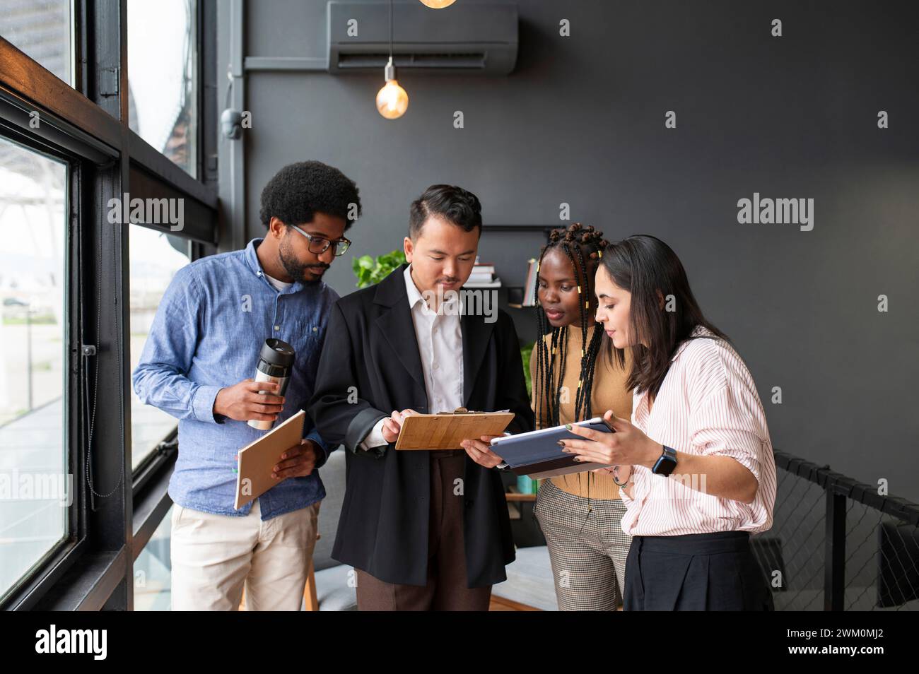 Uomini d'affari e donne d'affari che discutono sugli appunti in ufficio Foto Stock