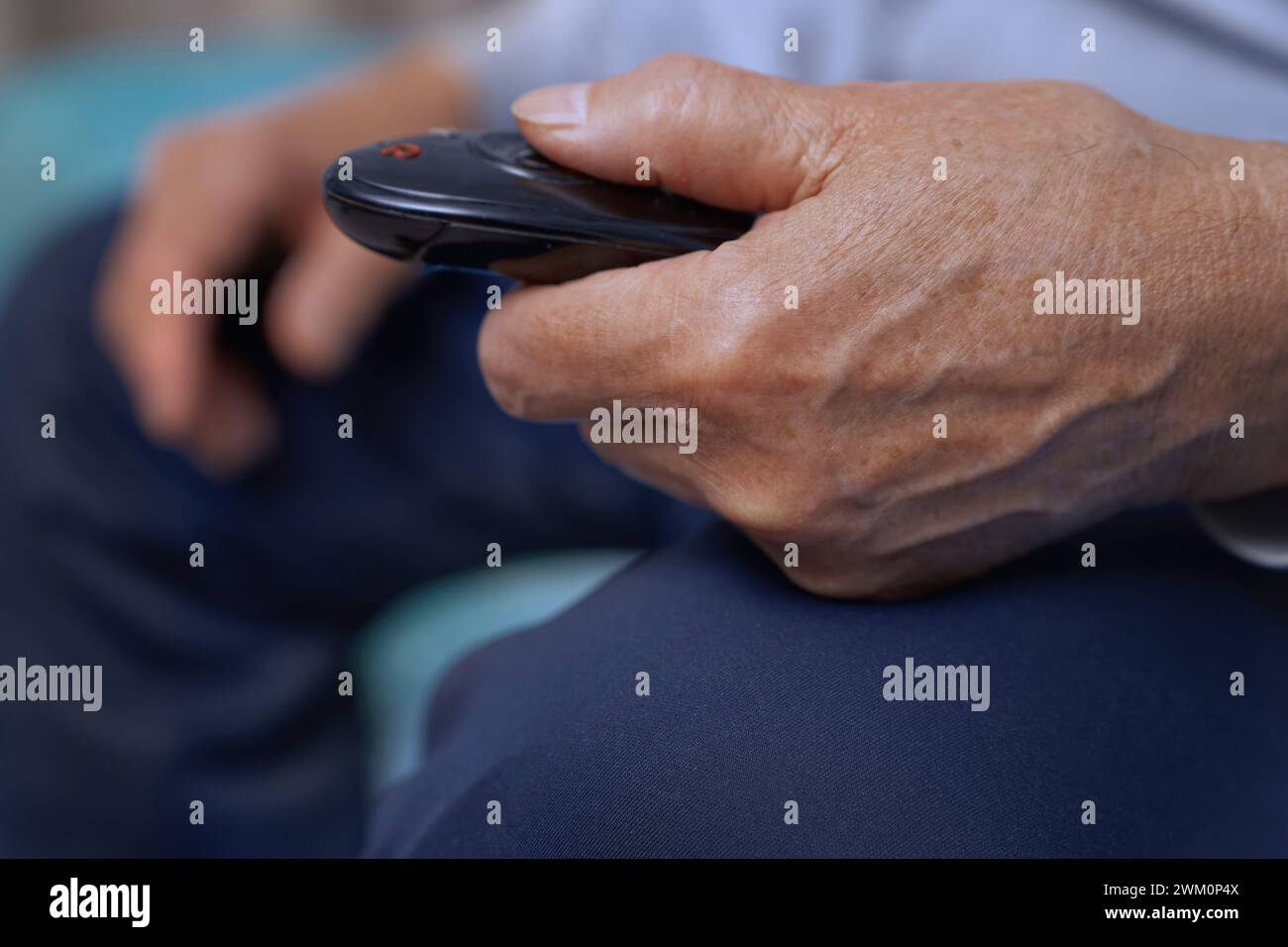 Uomo anziano con telecomando della TV Foto Stock