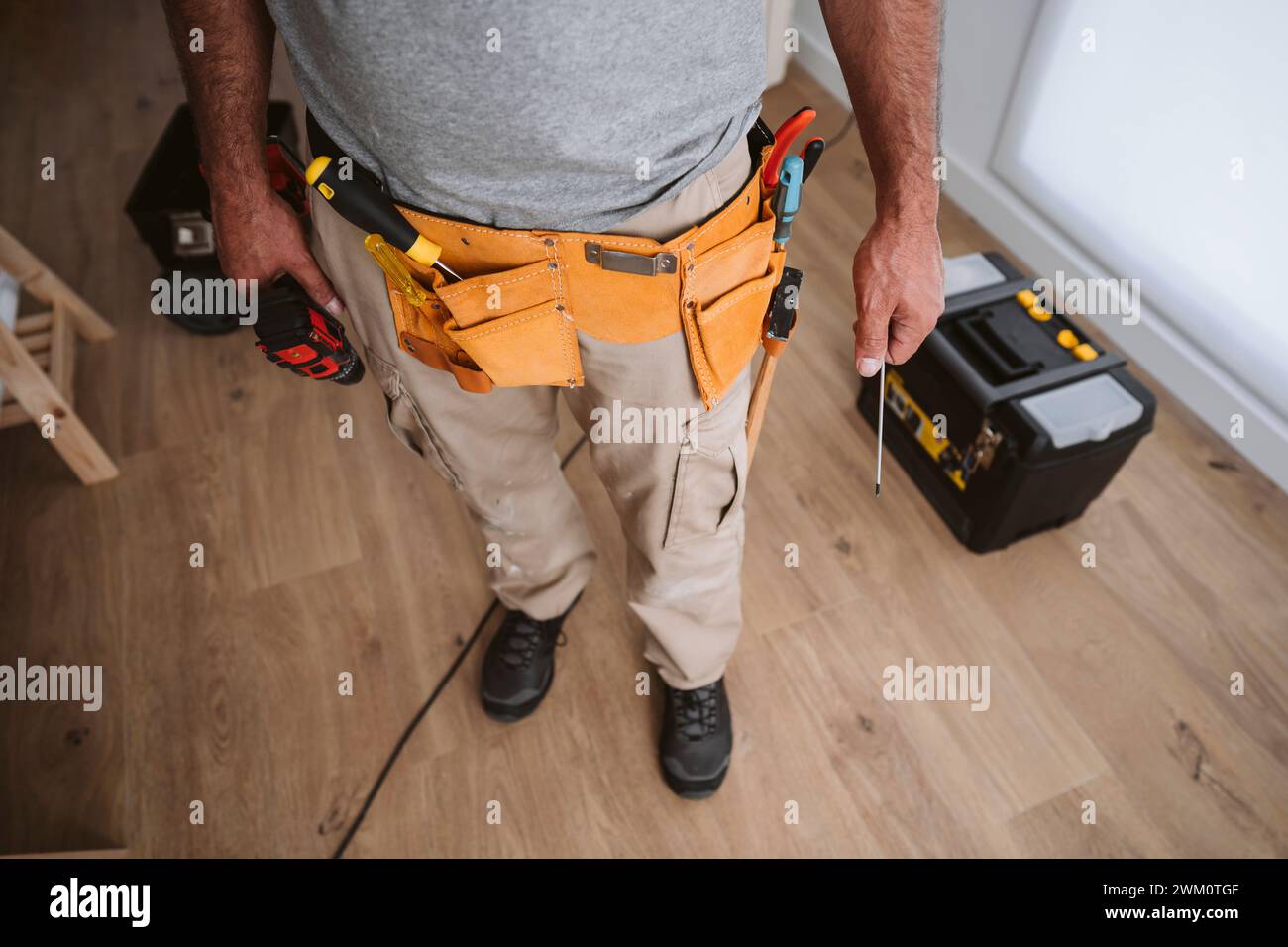 I riparatori indossano la cintura portautensili e si trovano a casa Foto Stock