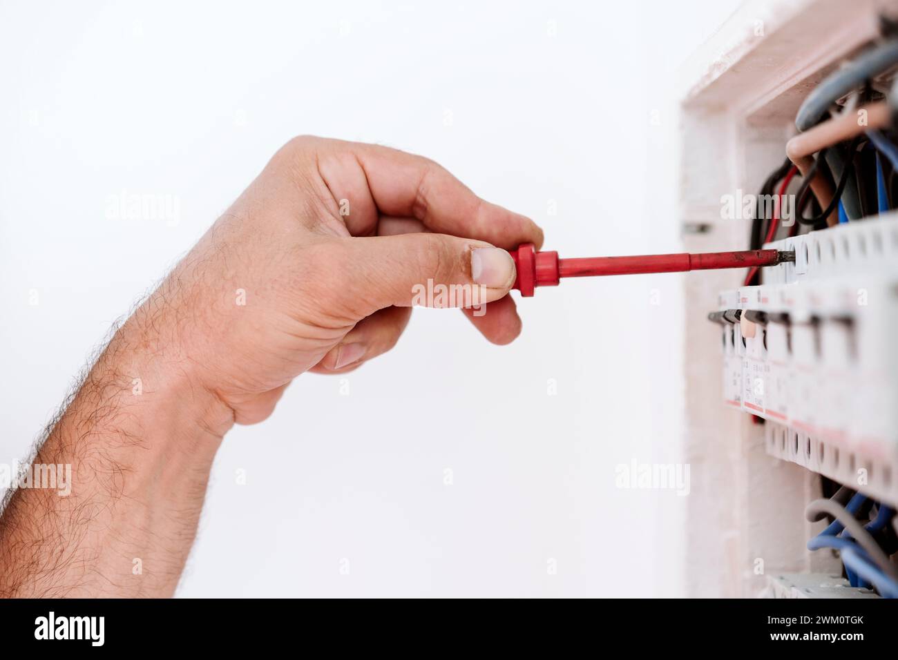Tecnico maturo che ripara la scatola fusibili a casa Foto Stock