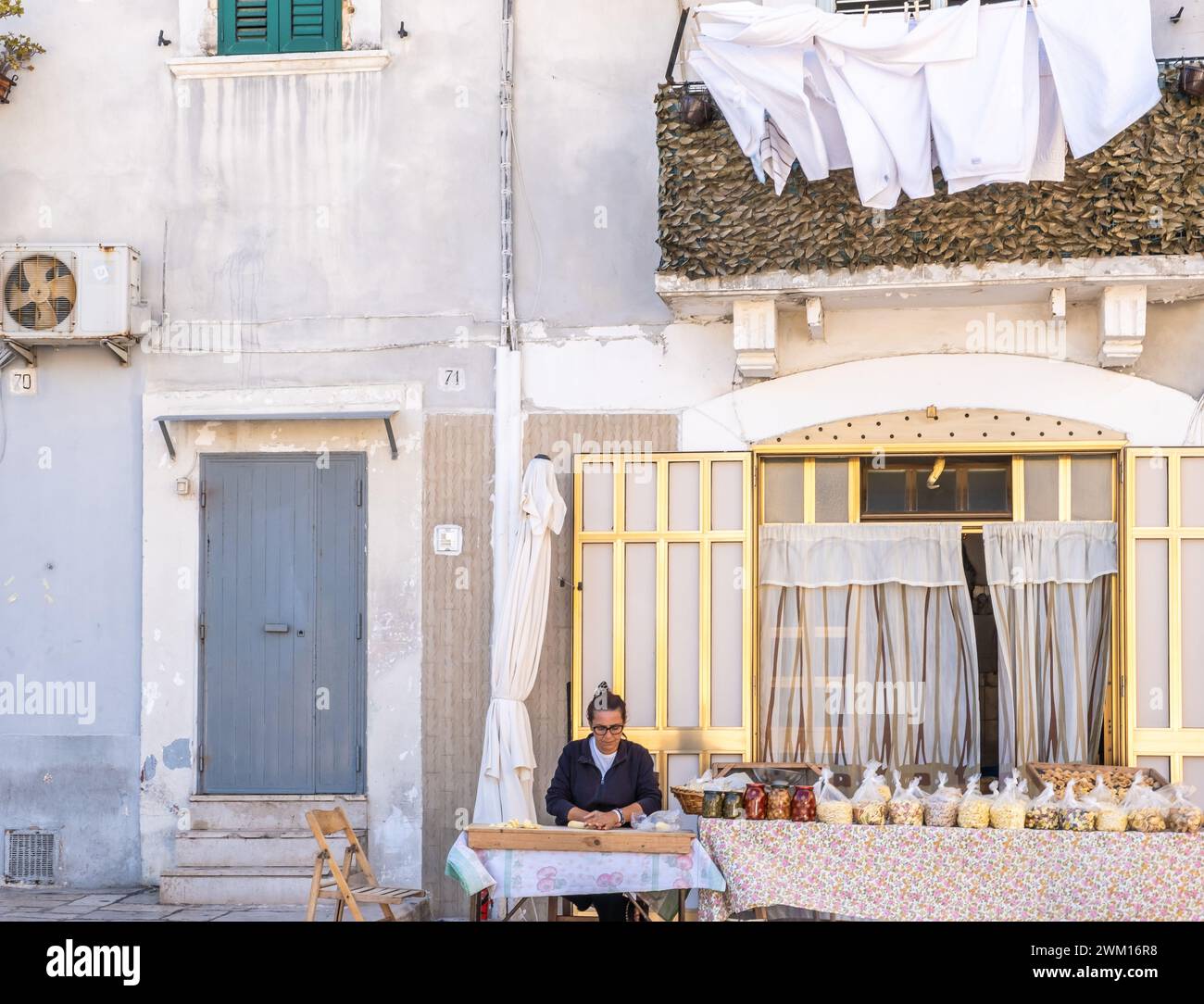 Donna che prepara le orecchiette, la tipica pasta pugliese, per strada nel centro di Bari, regione Puglia, Italia meridionale, Europa - 18 settembre 2022 Foto Stock