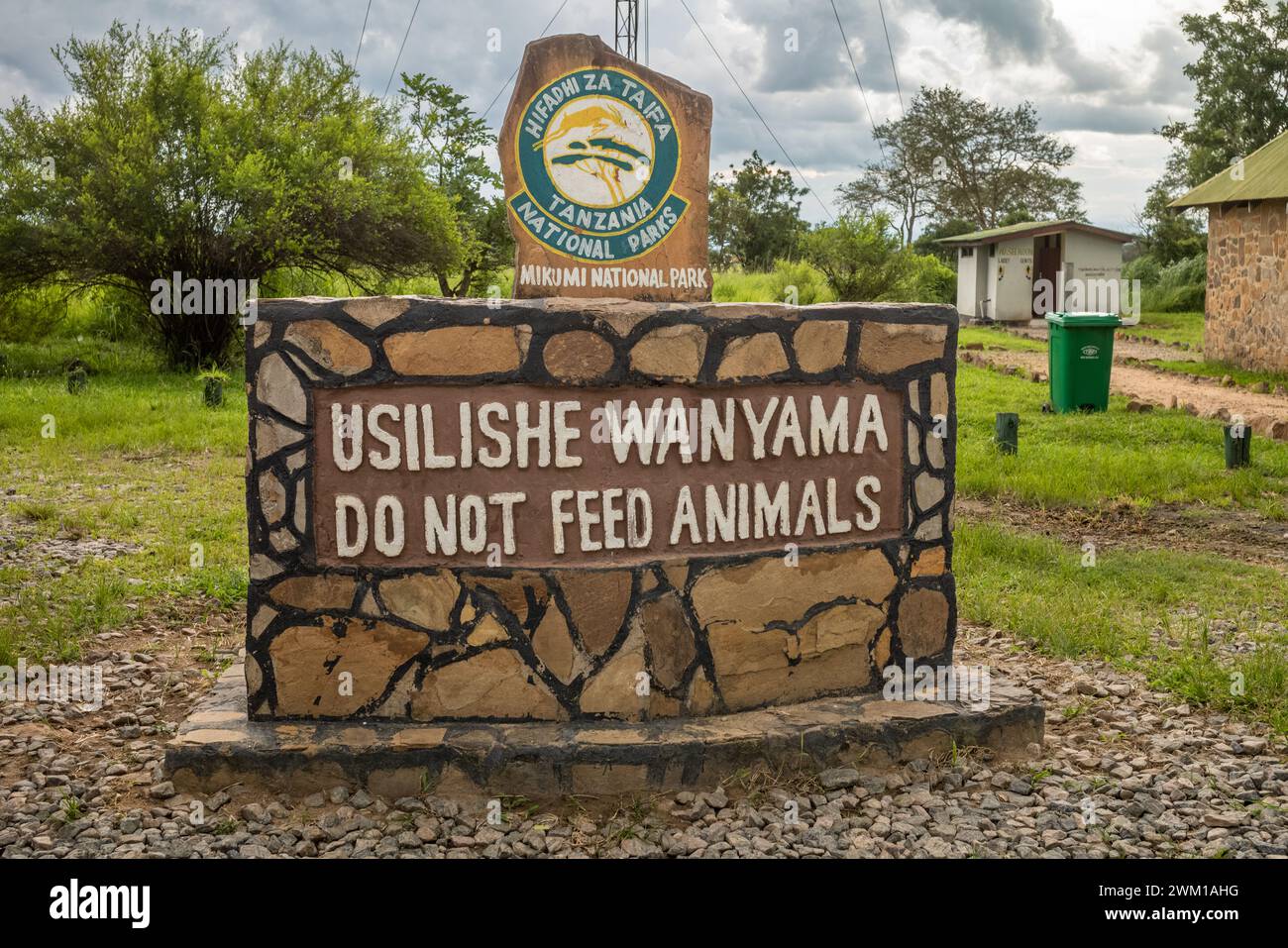 Un cartello costruito in pietra all'ingresso del Parco Nazionale di Mikumi in Tanzania avverte la gente di non dar da mangiare agli animali Foto Stock