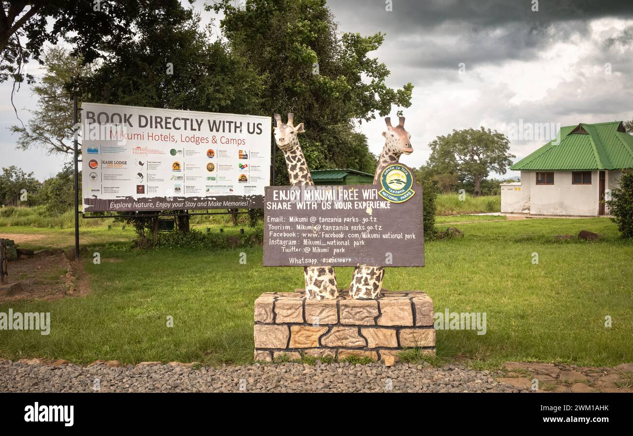 Indicazioni per hotel e Lodge e wifi gratuito accanto a un blocco WC all'ingresso principale del Parco Nazionale di Mikumi, Tanzania. Foto Stock
