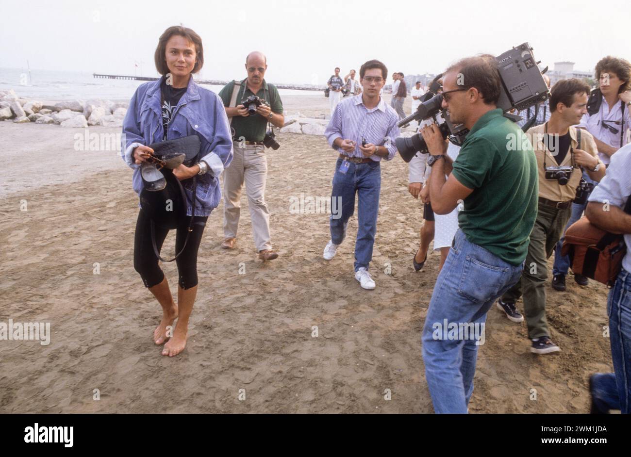4069626 Lido di Venezia, Mostra del Cinema di Venezia 1988. Fotografa fotografare l'attrice svedese Lena Olin, membro del Festival della giuria, sulla spiaggia del Lido (foto); (add.info.: Lido di Venezia, Lido di Venezia, Italia, Lido di Venezia, Mostra del Cinema di Venezia 1988. I fotografi ritraggono l'attrice svedese Lena Olin, membro della giuria, sulla spiaggia del Lido); © Marcello Mencarini. Tutti i diritti riservati 2024. Foto Stock