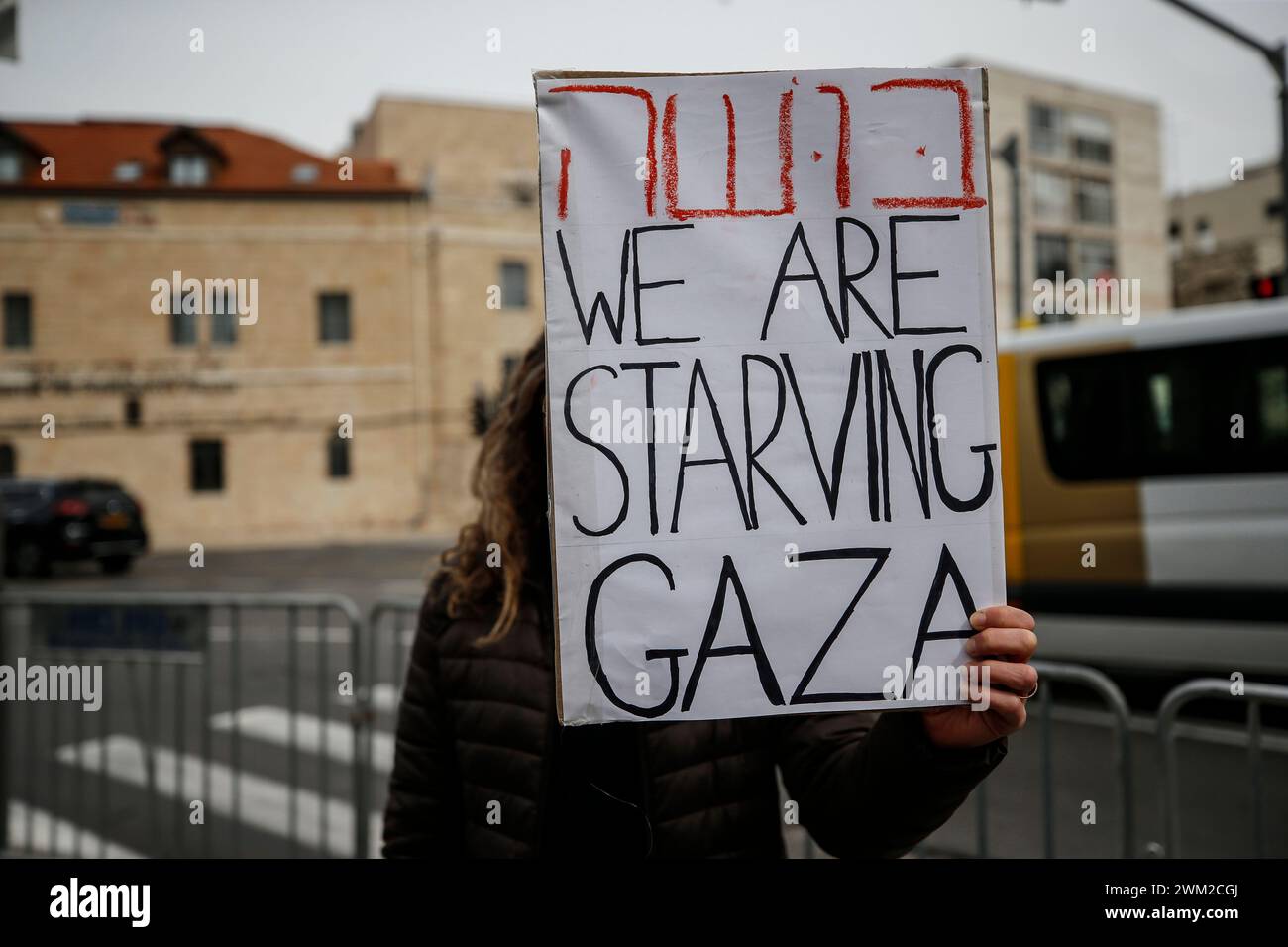 L'attivista israeliano contro la guerra ha un cartello con scritto "stiamo morendo di fame Gaza” in Piazza Parigi, vicino alla residenza del primo ministro israeliano Benjamin Netanyahu durante la manifestazione. I manifestanti si riunirono a Gerusalemme Ovest per denunciare il conflitto in corso tra Israele e Hamas, sollecitando un immediato cessate il fuoco. Chiesero anche uno scambio di ostaggi con Hamas. (Foto di Saeed Qaq / SOPA Images/Sipa USA) Foto Stock