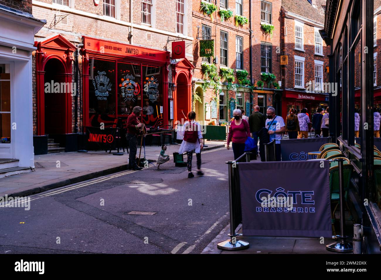 Turisti e visitatori su Low Petergate Street. York, North Yorkshire, Yorkshire e Humber, Inghilterra, Regno Unito, Europa Foto Stock