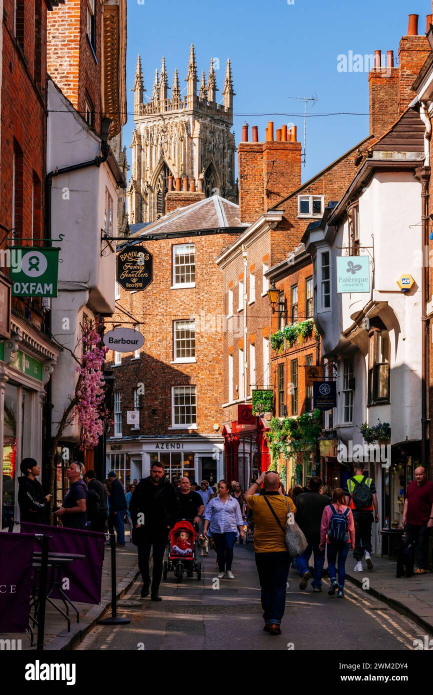 Ammira il nord-ovest lungo Low Petergate, con le torri della cattedrale di York sullo sfondo. York, North Yorkshire, Yorkshire e Humber, Inghilterra, Re Unito Foto Stock