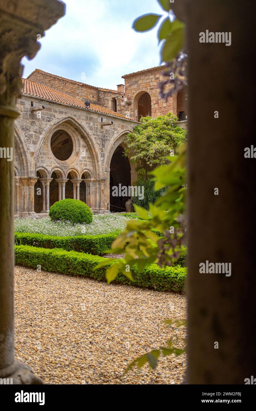 Ripresa verticale del chiostro dell'Abbazia di Fontfroide in Francia. Foto scattata in una giornata di sole primaverile attraverso un colonnato senza persone Foto Stock