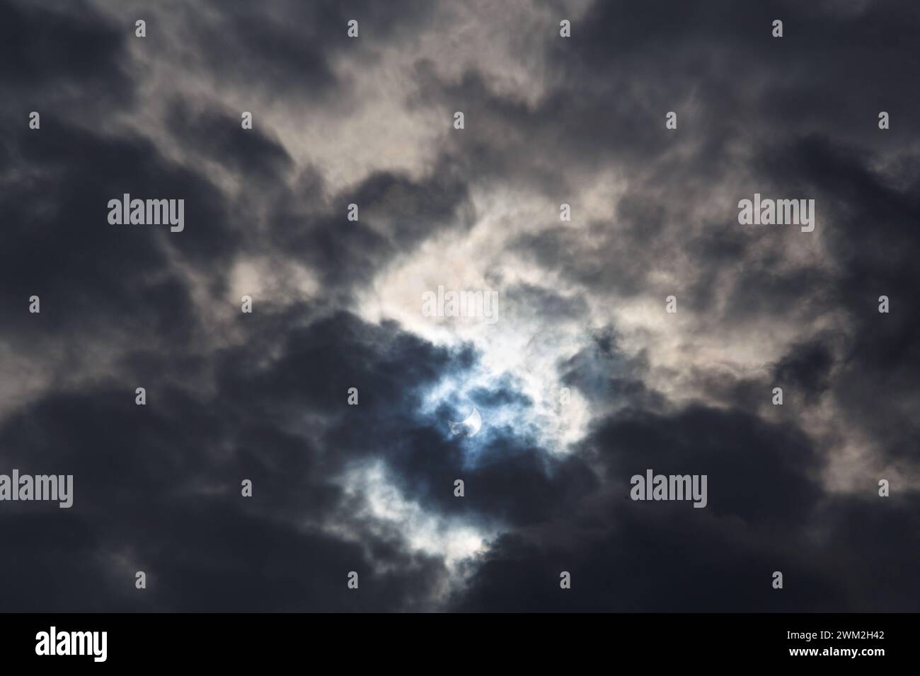 Un'eclissi solare parziale del 25 ottobre 2022 catturata attraverso nuvole buie lunari, la fase massima visibile dall'Europa, Romania. Foto Stock