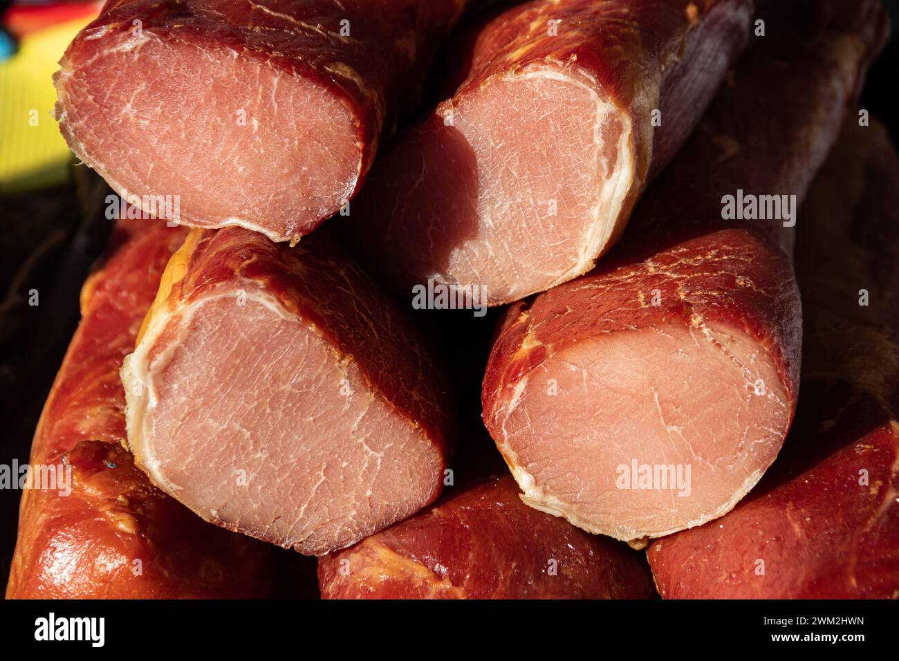 Deliziosi pezzi di carne affumicata esposti per la vendita nel mercato presentato in vendita in un mercato agricolo nel villaggio di Kacarevo, festival del bacon gastronomico Foto Stock