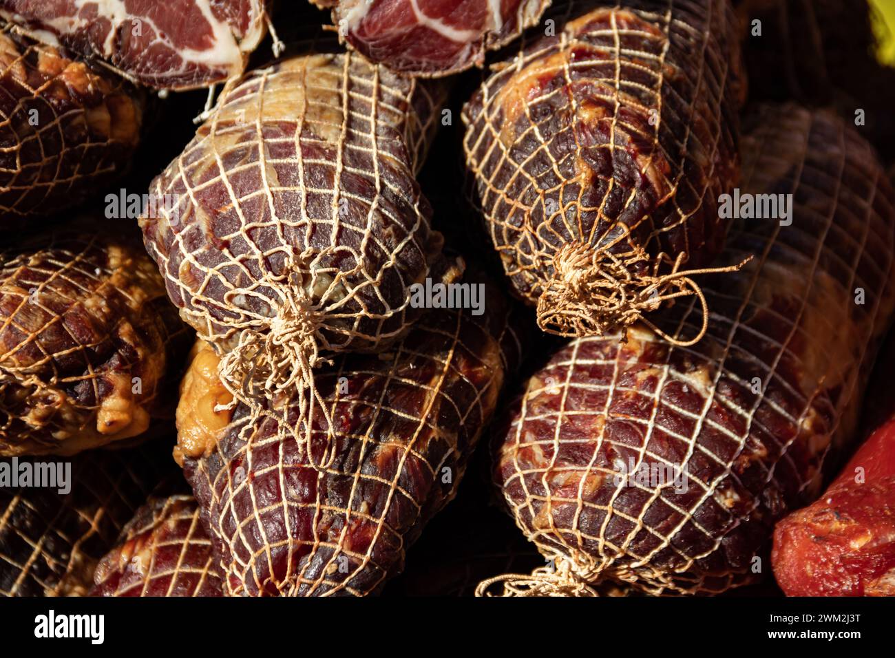 Deliziosi pezzi di carne affumicata esposti per la vendita nel mercato presentato in vendita in un mercato agricolo nel villaggio di Kacarevo, festival del bacon gastronomico Foto Stock