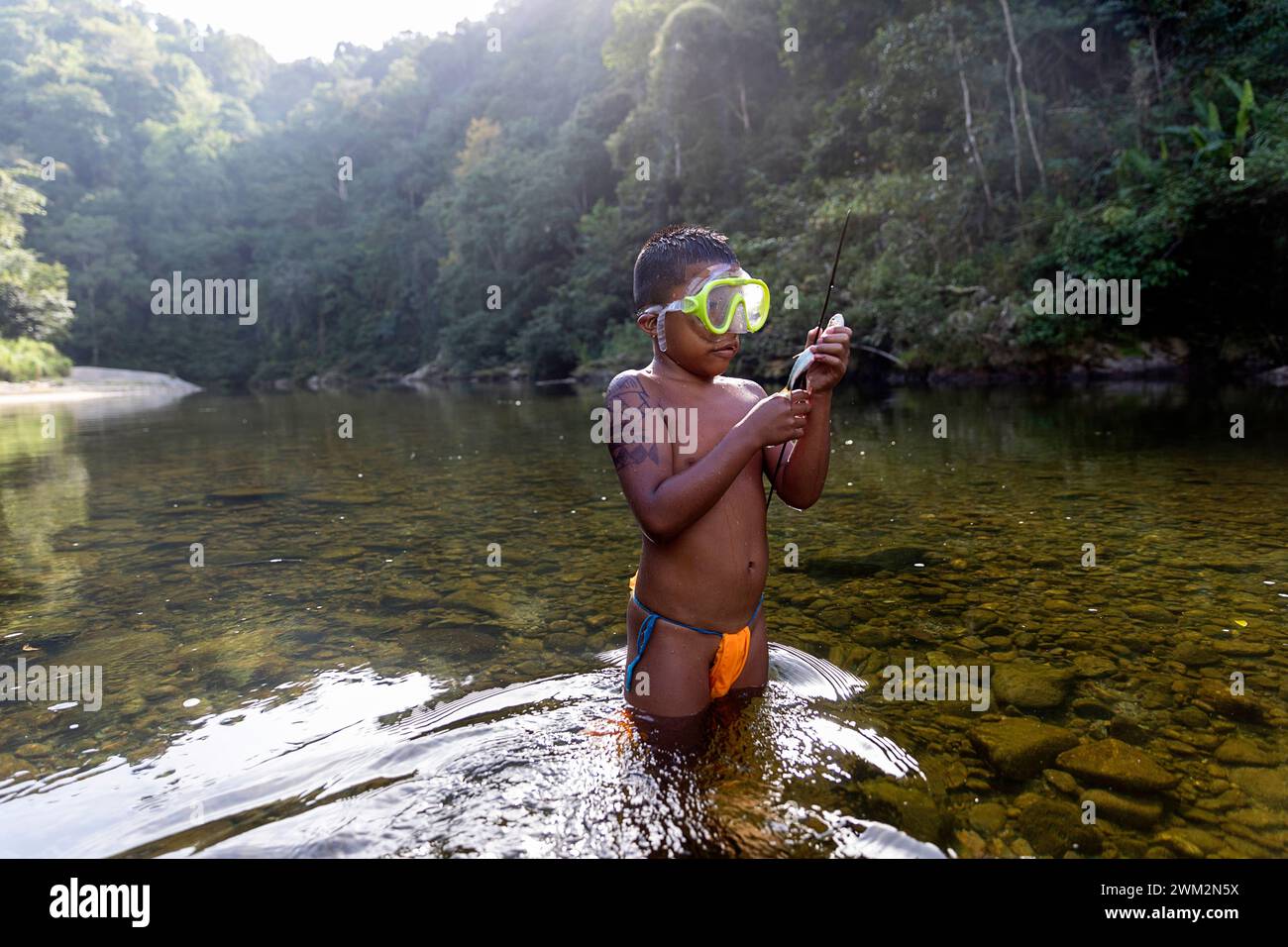 Pescatore indigeno Embera con una lancia fatta a mano accanto a un fiume nella foresta pluviale tropicale del Panama, rappresentativo della vita e della cultura tradizionale. Foto Stock