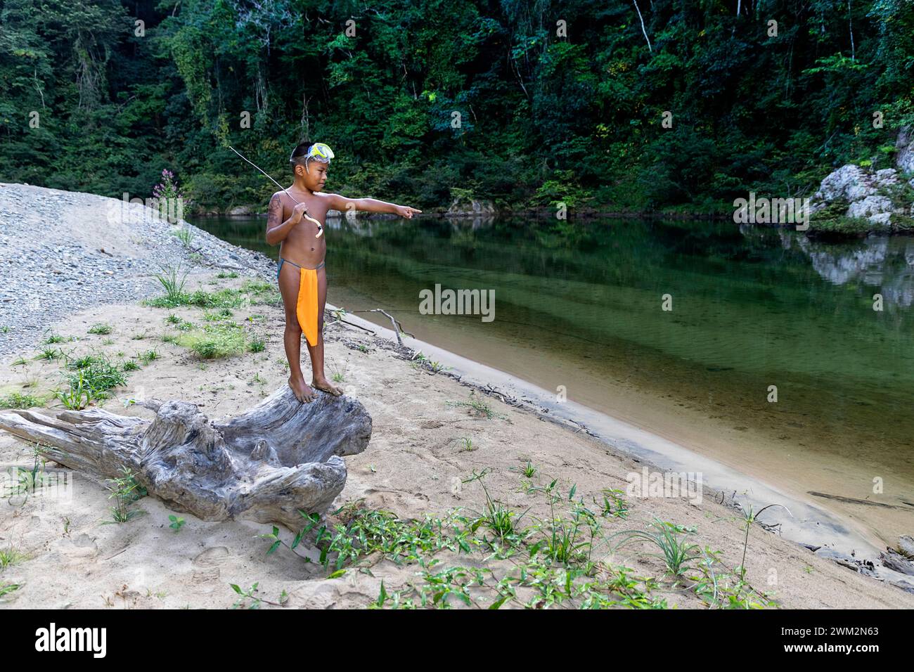 Pescatore indigeno Embera con una lancia fatta a mano accanto a un fiume nella foresta pluviale tropicale del Panama, rappresentativo della vita e della cultura tradizionale. Foto Stock
