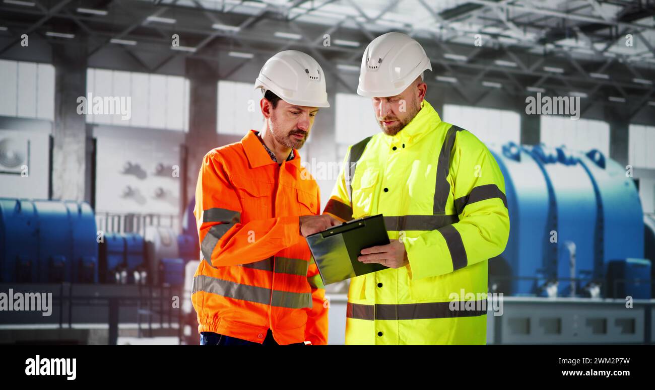 Ingegneri che controllano gli impianti industriali. Ispezione OSHA presso la centrale elettrica Foto Stock