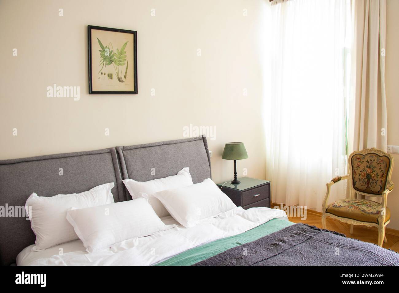 Un letto spazioso decorato con cuscini e cuscini bianchi Foto Stock