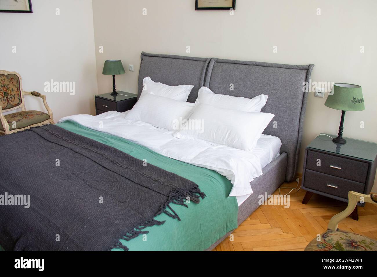 Un letto ben fatto con due comodini su ogni lato Foto Stock