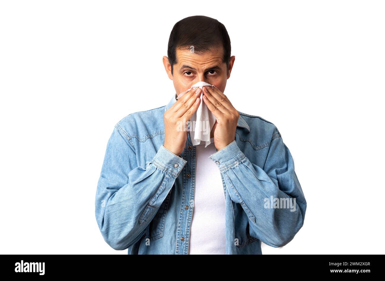 Ritratto di un uomo che soffia il naso con un fazzoletto mentre si trova su uno sfondo bianco Foto Stock