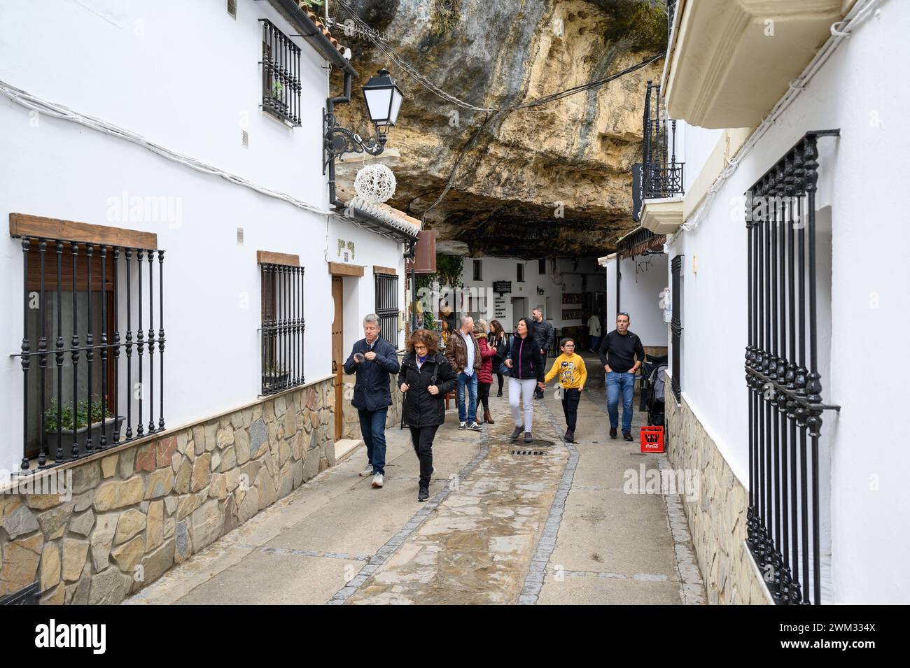 Strada tipica del villaggio bianco di Setenil de las Bodegas con le case incastonate nelle rocce della montagna, a Cadice, Spagna. Foto Stock