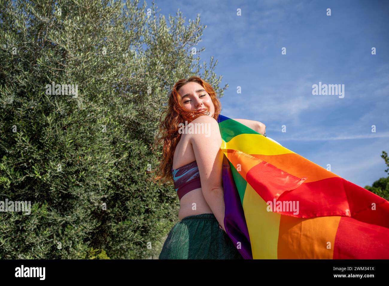 Ragazza rossa sorridente con la bandiera LGBT Foto Stock