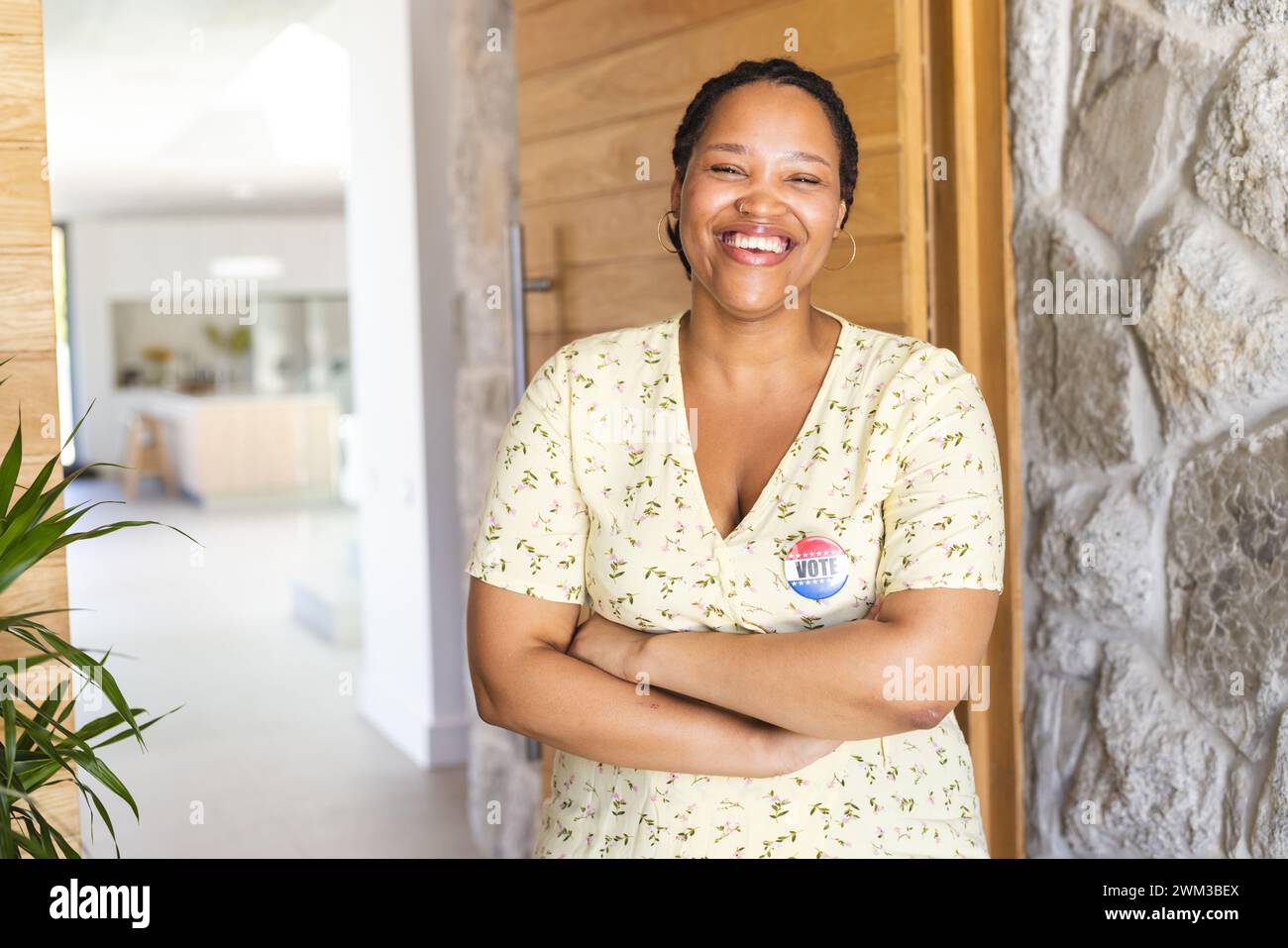 La giovane donna birazziale si trova a casa con sicurezza e indossa un distintivo "Vote", con spazio per le copie Foto Stock