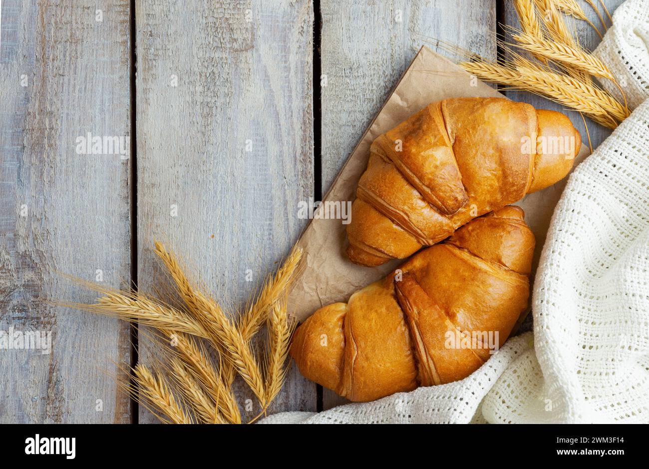 Pasticceria francese fresca e deliziosa, panetteria, immagine ravvicinata. Croissant croccante al forno su tavola di legno, colazione. Cibo per la colazione dalla France Bak Foto Stock