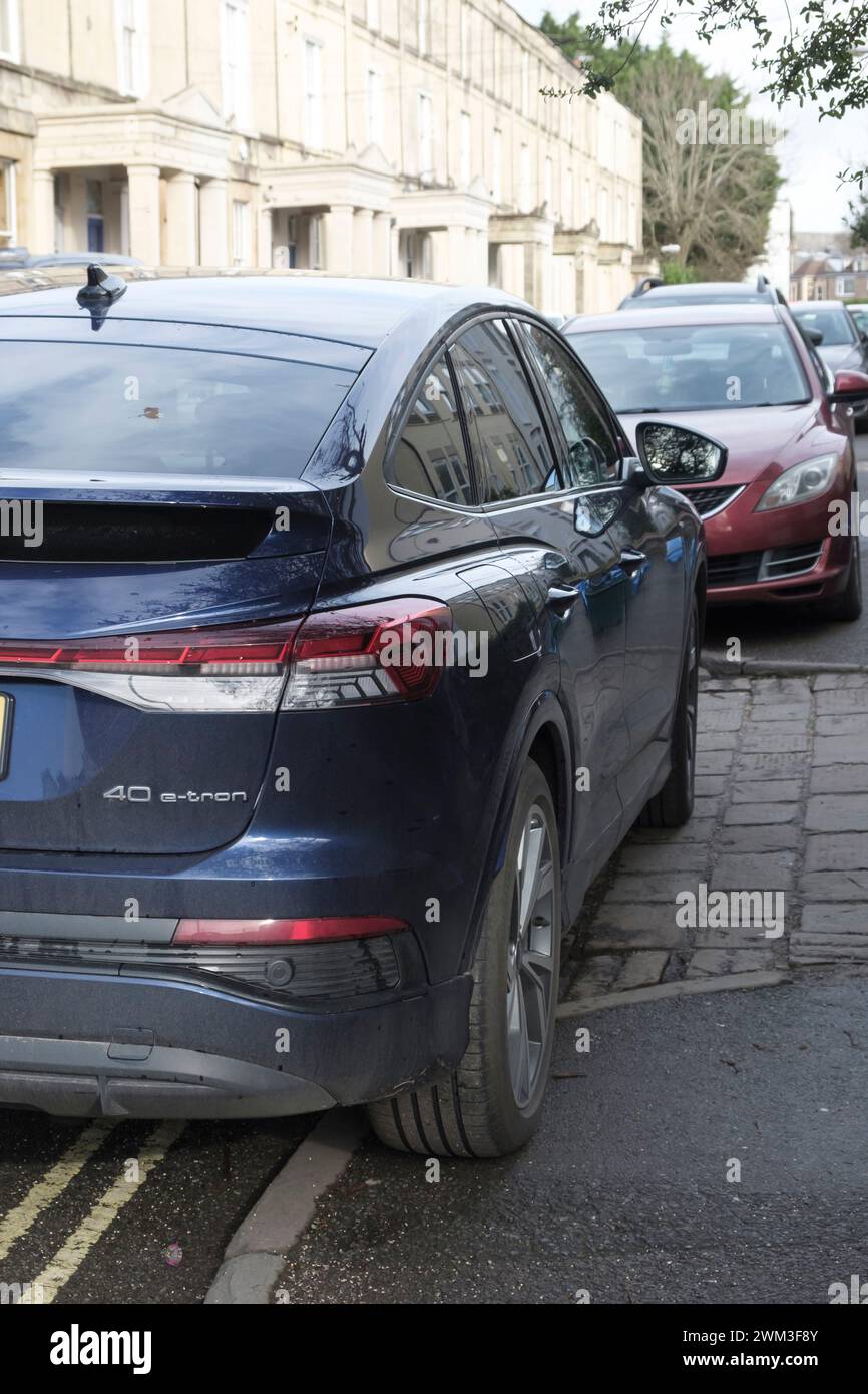 Auto parcheggiata su un marciapiede e su una doppia linea gialla Foto Stock