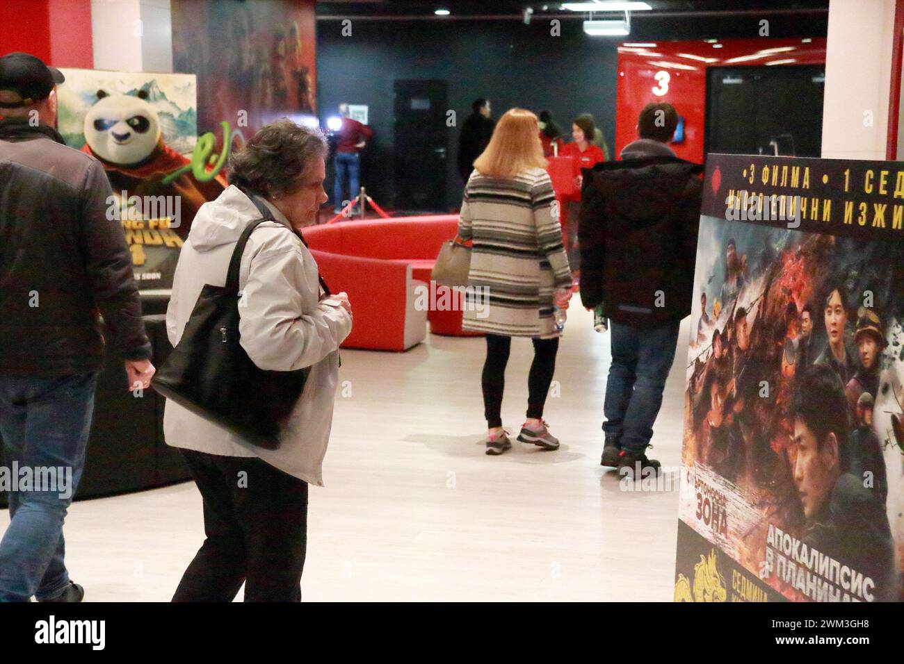 Sofia, Bulgaria. 23 febbraio 2024. Una donna guarda un poster della settimana del cinema cinese a Sofia, Bulgaria, il 23 febbraio 2024. Venerdì è iniziata la settimana del cinema cinese nelle sale cinematografiche di cinque grandi città della Bulgaria. Crediti: Marian Draganov/Xinhua/Alamy Live News Foto Stock