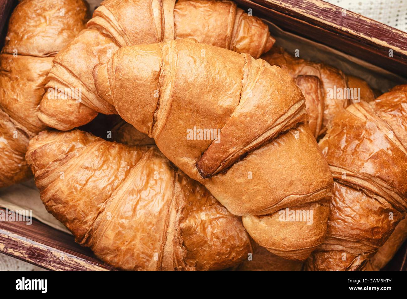 Croissant francesi dorati appena sfornati. Deliziosi croissant dolci. tradizionale pasticceria francese fatta in casa a colazione. Croissant per puf Foto Stock