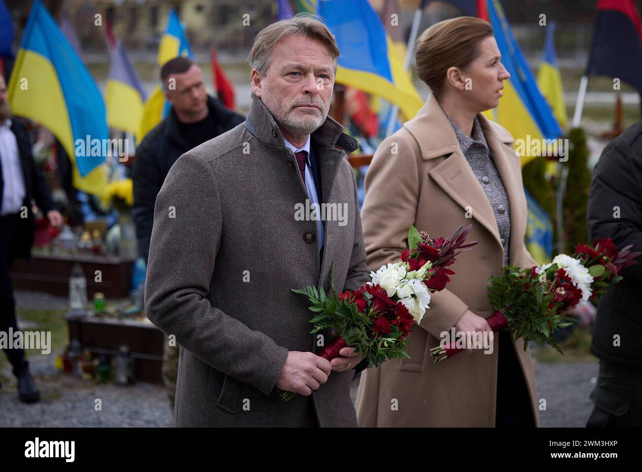 Leopoli, Ucraina. 23 febbraio 2024. Il primo ministro danese mette Frederiksen, a destra, e il marito Bo Tengberg, a sinistra, rendono omaggio ai soldati caduti sul campo di Marte all'interno del cimitero di Lychakiv, 23 febbraio 2024 a Leopoli, Ucraina. Credito: Pool Photo/Ufficio Stampa Presidenziale ucraino/Alamy Live News Foto Stock