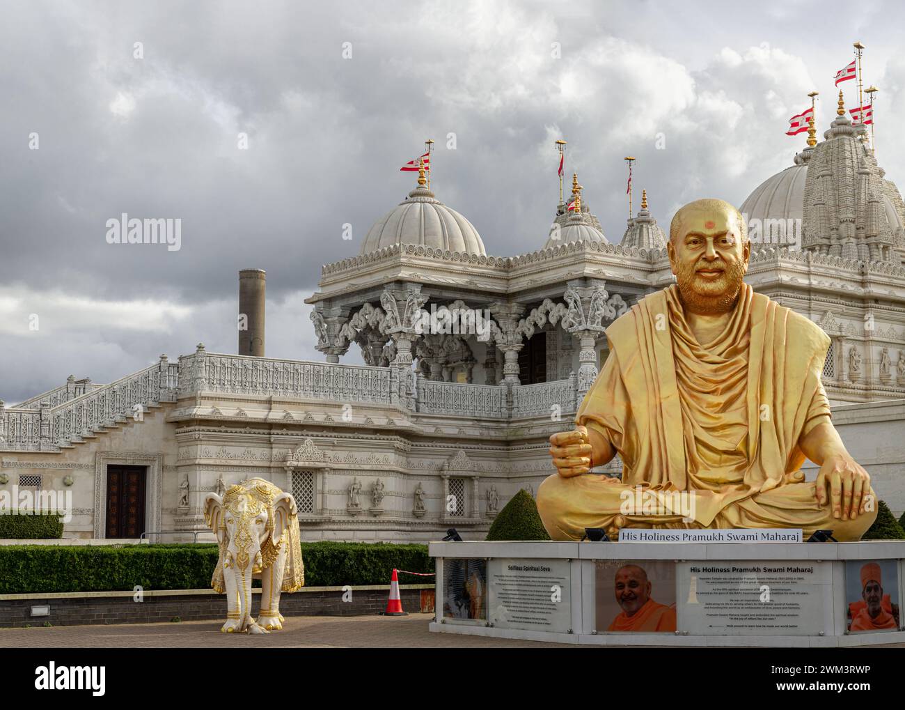 Londra, Regno Unito - 23 febbraio 2024 - la statua color oro del leader spirituale santità pramukh swami maharaj davanti al tempio Neasden (BAPS Shri Swaminarayan Foto Stock