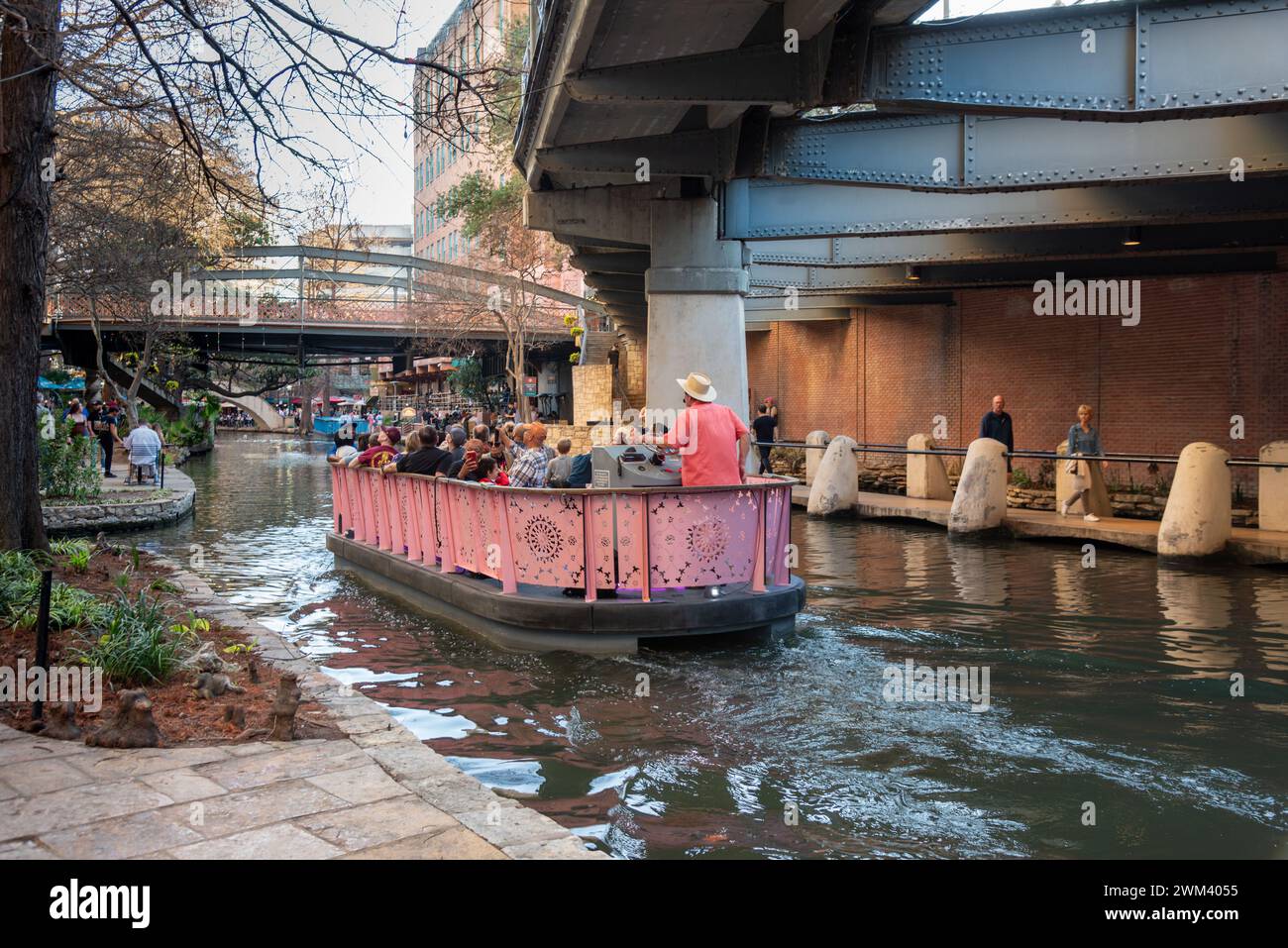 Crociera in barca rosa colorata con guida turistica sulla passeggiata lungo il fiume San Antonio, San Antonio, Texas, Stati Uniti. Foto Stock