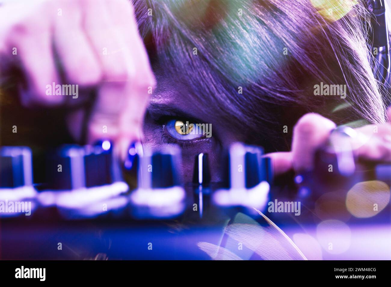 L'attento occhio di gatto del DJ, che si aggrava con creatività, supervisiona il mix preciso dei brani Foto Stock