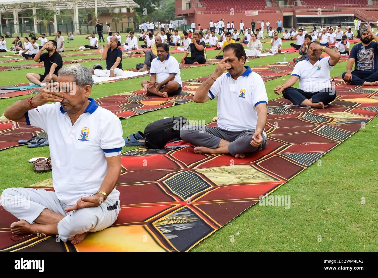 Nuova Delhi, India, 21 giugno 2023 - sessione di esercizi di gruppo di Yoga per le persone al complesso sportivo Yamuna di Delhi in occasione della giornata Internazionale dello Yoga, grande gruppo di adu Foto Stock