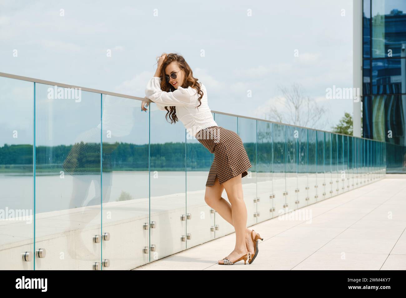 Giovane donna sorridente in piedi sul ponte di osservazione Foto Stock