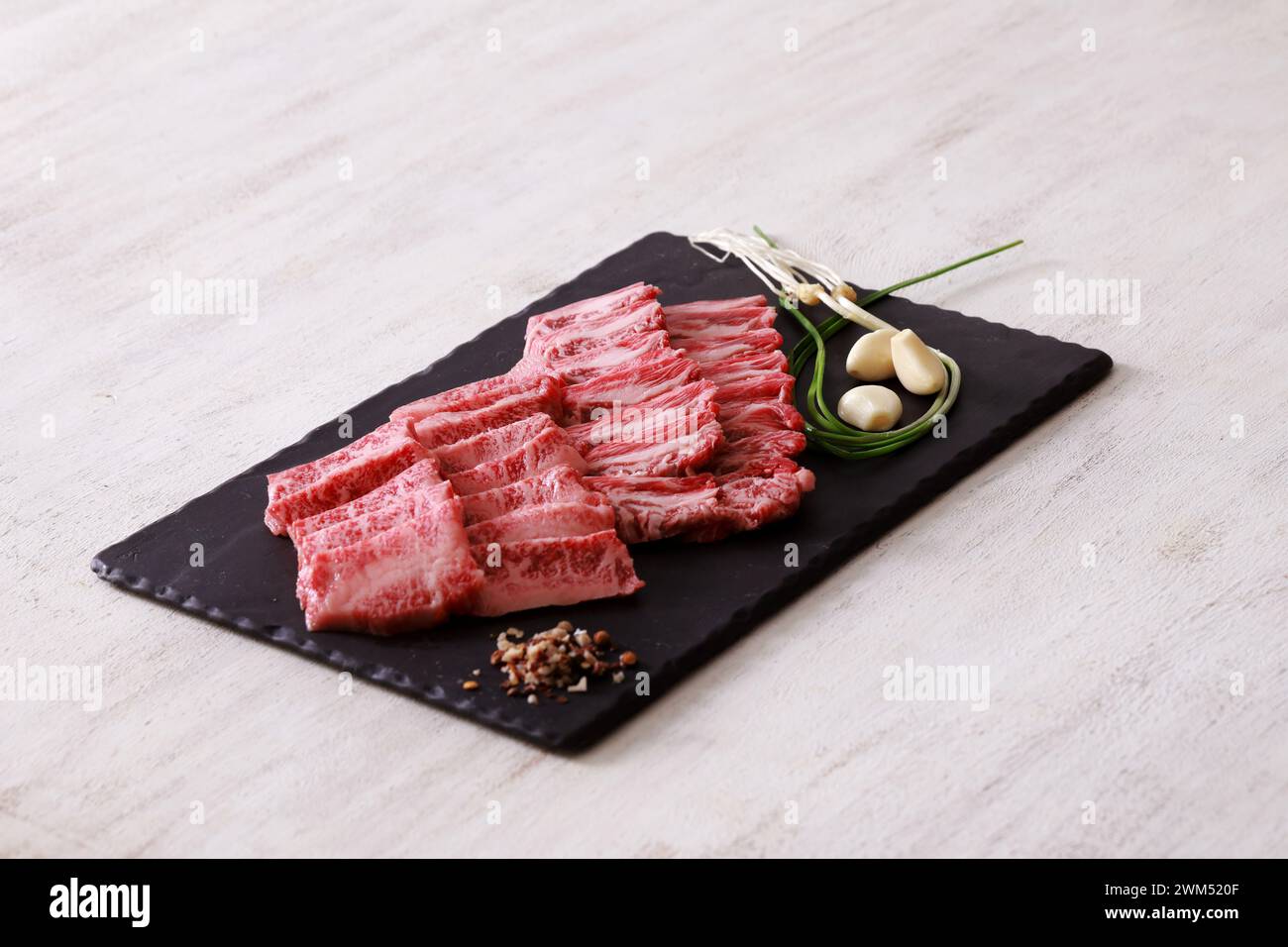 Controfiletto di manzo coreano fresco crudo tagliato su un piatto di ardesia nera Foto Stock