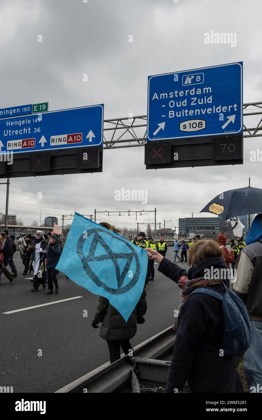 Amsterdam, Paesi Bassi. 24 febbraio 2024. Gli attivisti della ribellione per l'estinzione conducono il blocco A10 per protestare contro il finanziamento dell'industria dei combustibili fossili da parte di ING. I manifestanti chiudono la strada principale nel centro della città per sensibilizzare l'opinione pubblica sulle preoccupazioni ambientali. Crediti: Drew McArthur/Alamy Live News Foto Stock