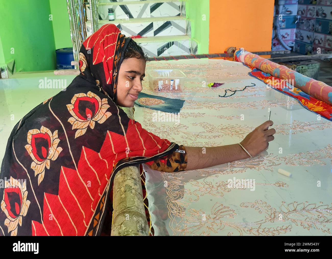 La giovane donna creò le sue opere d'arte cucendo in tessuto (Saree) per il suo sostentamento nel Bengala Occidentale in India. Foto Stock