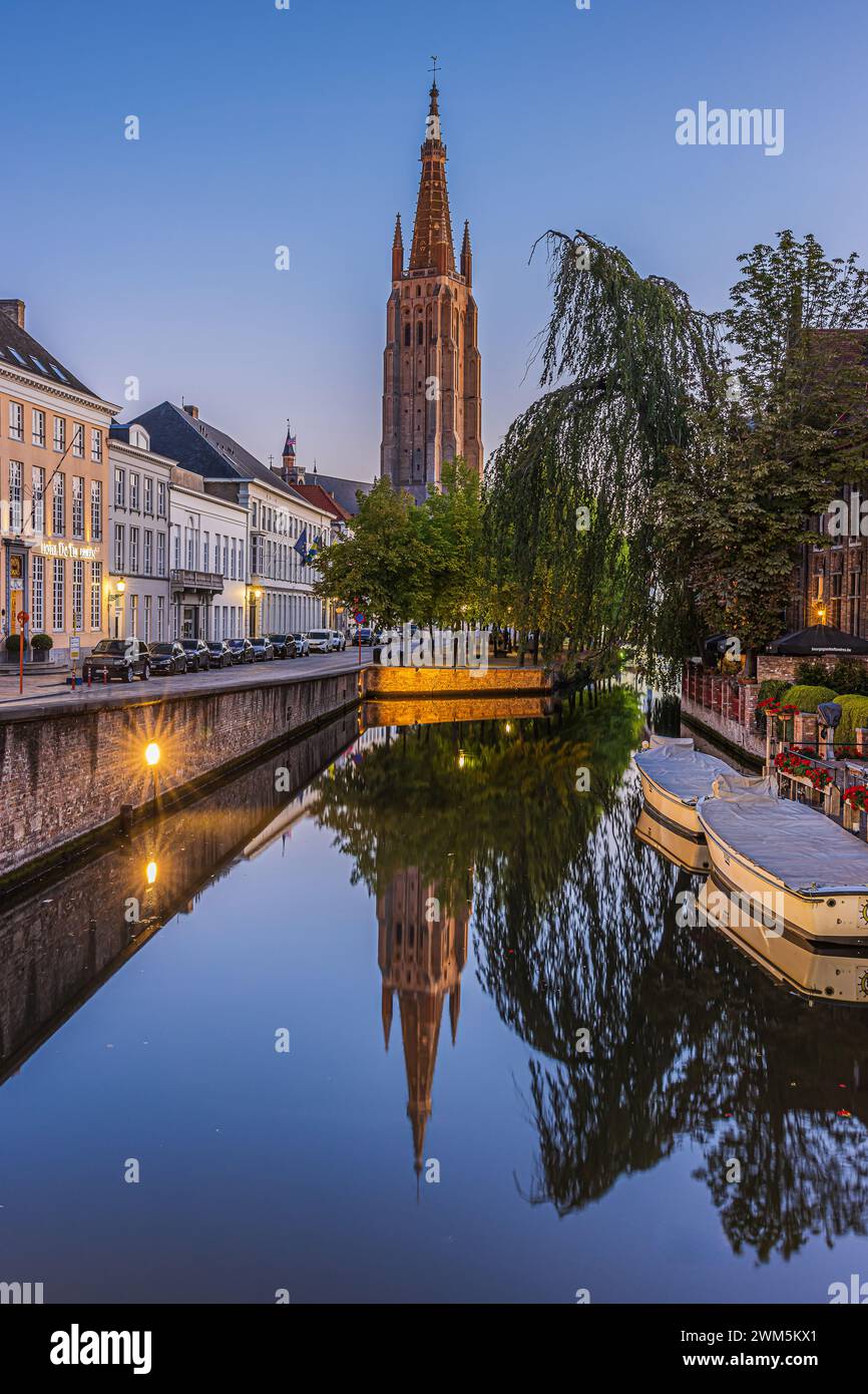 Canal a Bruges la sera. Case storiche e la Chiesa di nostra Signora nel centro della città vecchia della città anseatica belga. Barche Foto Stock Canal a Bruges la sera. Case storiche e la Chiesa di nostra Signora nel centro della città vecchia della città anseatica belga. Barche Foto Stock