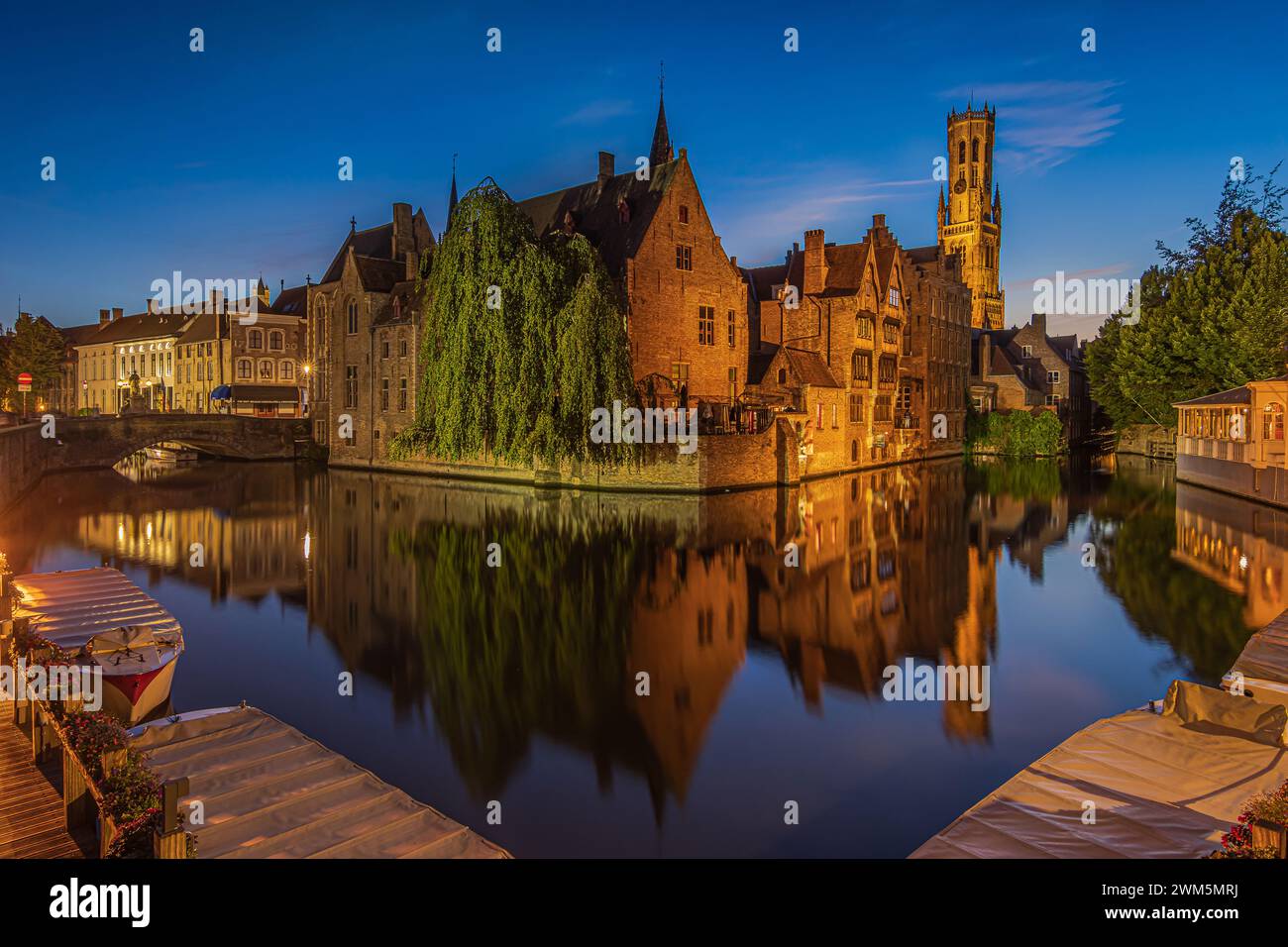 Rosary Quay la sera a Bruges. Centro della vecchia città anseatica con canale all'ora blu. Riflessi di storiche case mercantili illuminate Foto Stock Rosary Quay la sera a Bruges. Centro della vecchia città anseatica con canale all'ora blu. Riflessi di storiche case mercantili illuminate Foto Stock