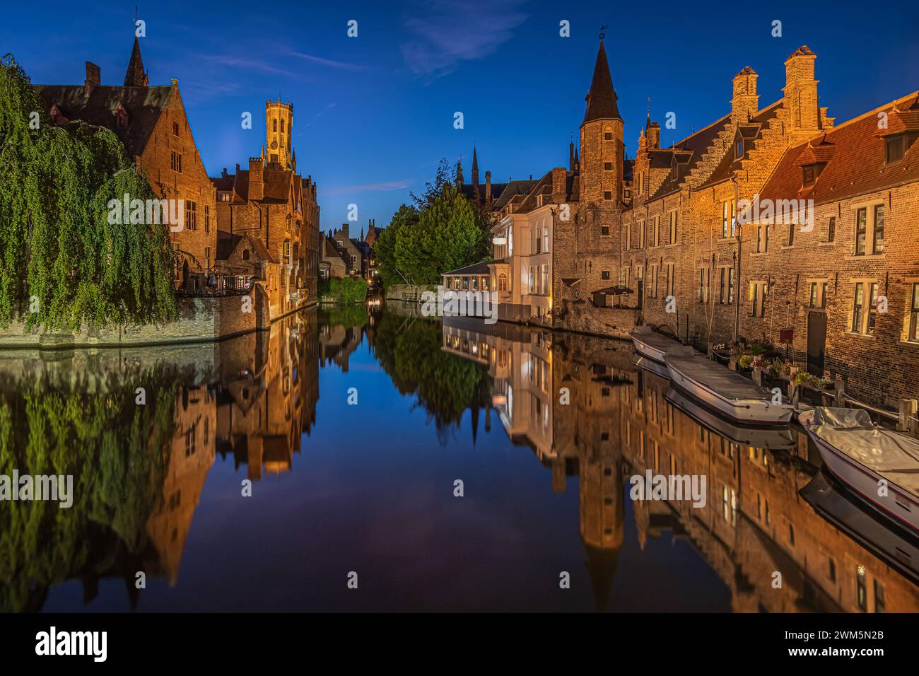 Canale di Bruges la sera. Rosary Quay nel centro della città vecchia della città anseatica. Storiche case mercantili illuminate con riflessi Foto Stock Canale di Bruges la sera. Rosary Quay nel centro della città vecchia della città anseatica. Storiche case mercantili illuminate con riflessi Foto Stock