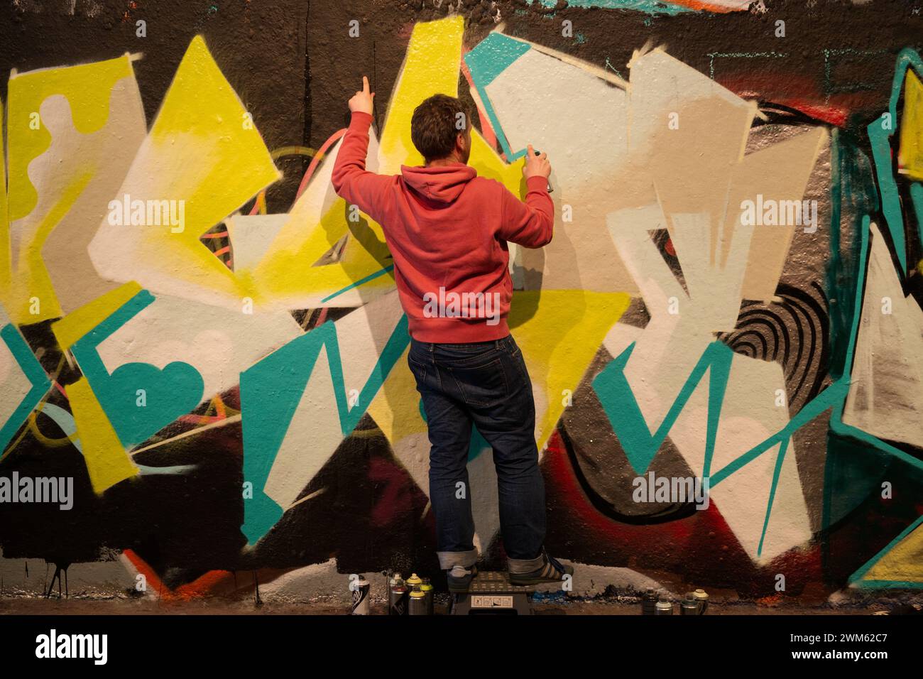 Un uomo che dipinge graffiti in Leake Street - Londra Foto Stock
